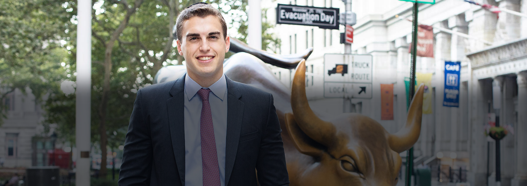 Michael Klein standing in front of a charging bull statue