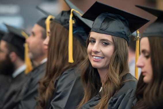 Female student in cap and gown smiing