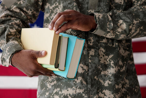 Soldier carrying books with flag background
