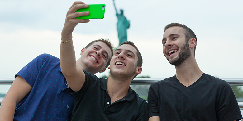 katz students taking selfie in front of statue of liberty