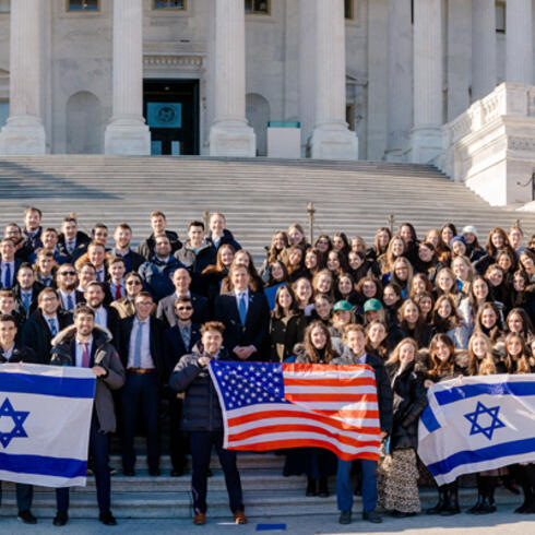 Yeshiva University students stand on the Capitol steps holding U.S. and Israeliflags