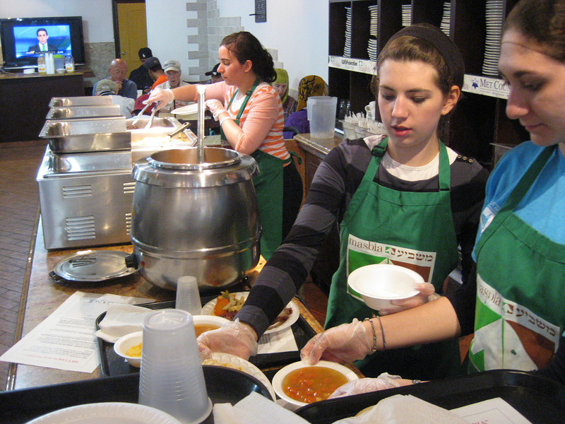 Shaina Joyandeh, Lila Bleich, and Nechama Rollhaus prepare food at a Masbia soup kitchen in Brooklyn, NY.
