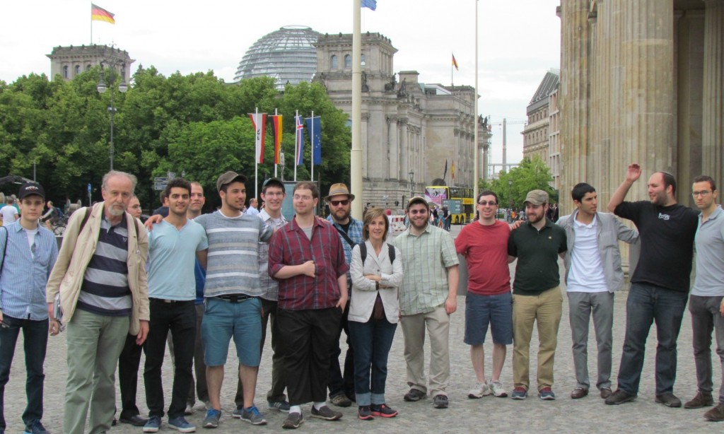 Students in a plaza across the street from the Holocaust memorial. In the background is the ceiling of the Bundestag (the German Parliament) and part of the Brandenburg Gate.