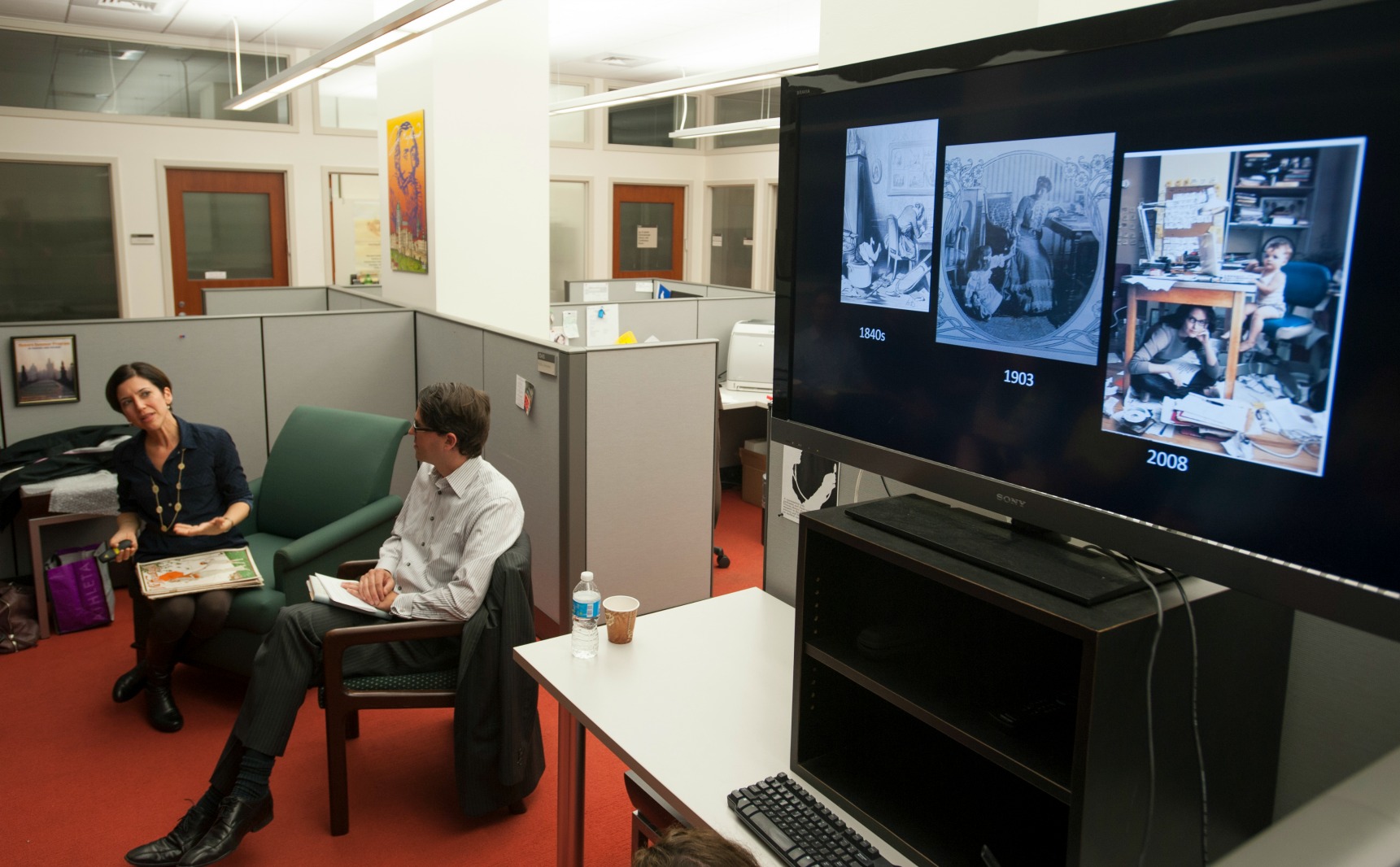 Dr. Mesch and Dr. Marnin Young discuss images from the magazines shown on the screen. 