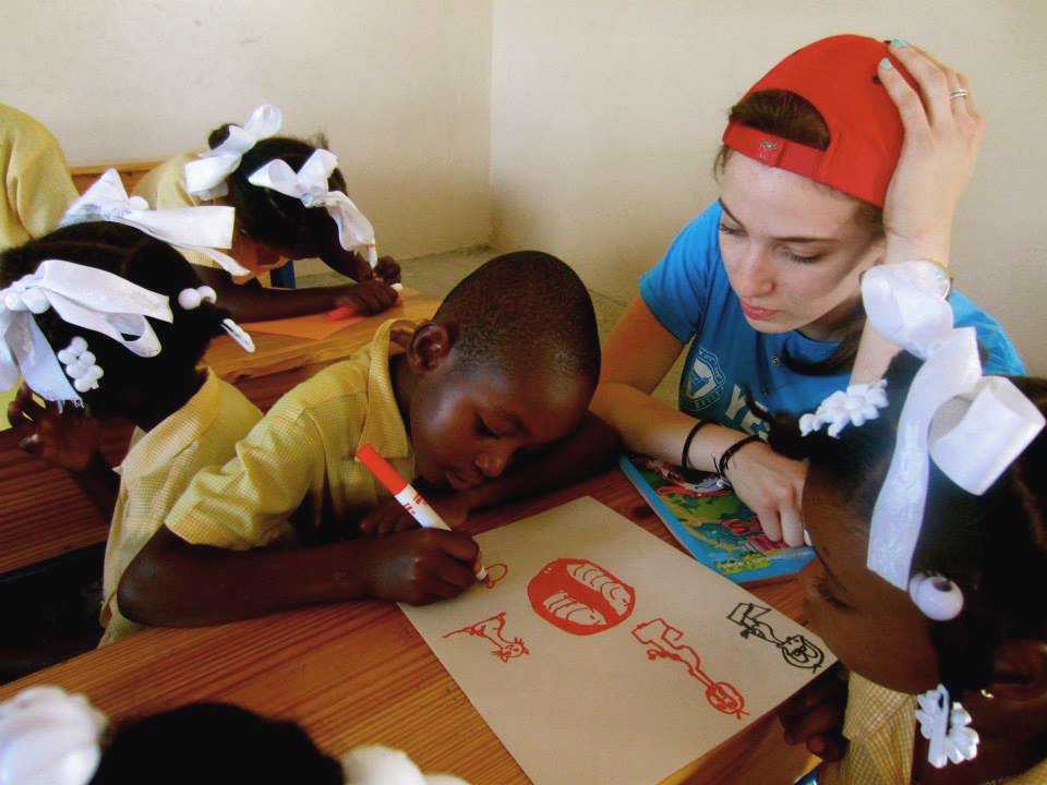 Esther Shmunis, a participant on the Haiti mission, works on an art project with a student in Zoranje.