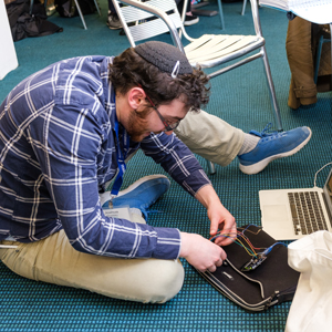 Man sitting on floor wiring a computer