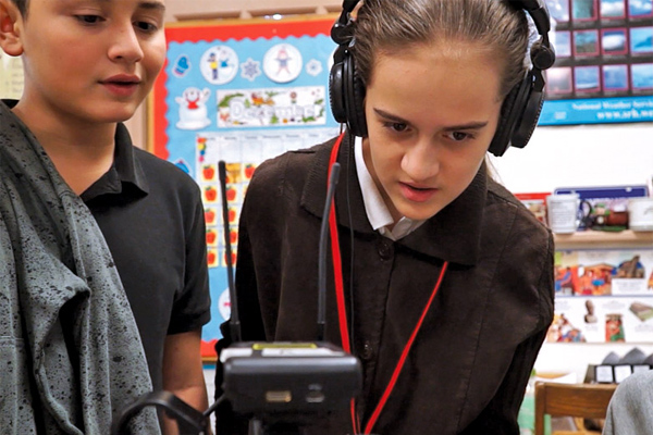 Two students editing video from their interviews