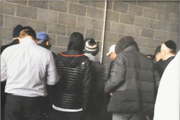 Group of men davening at NFL game at Metlife Stadium